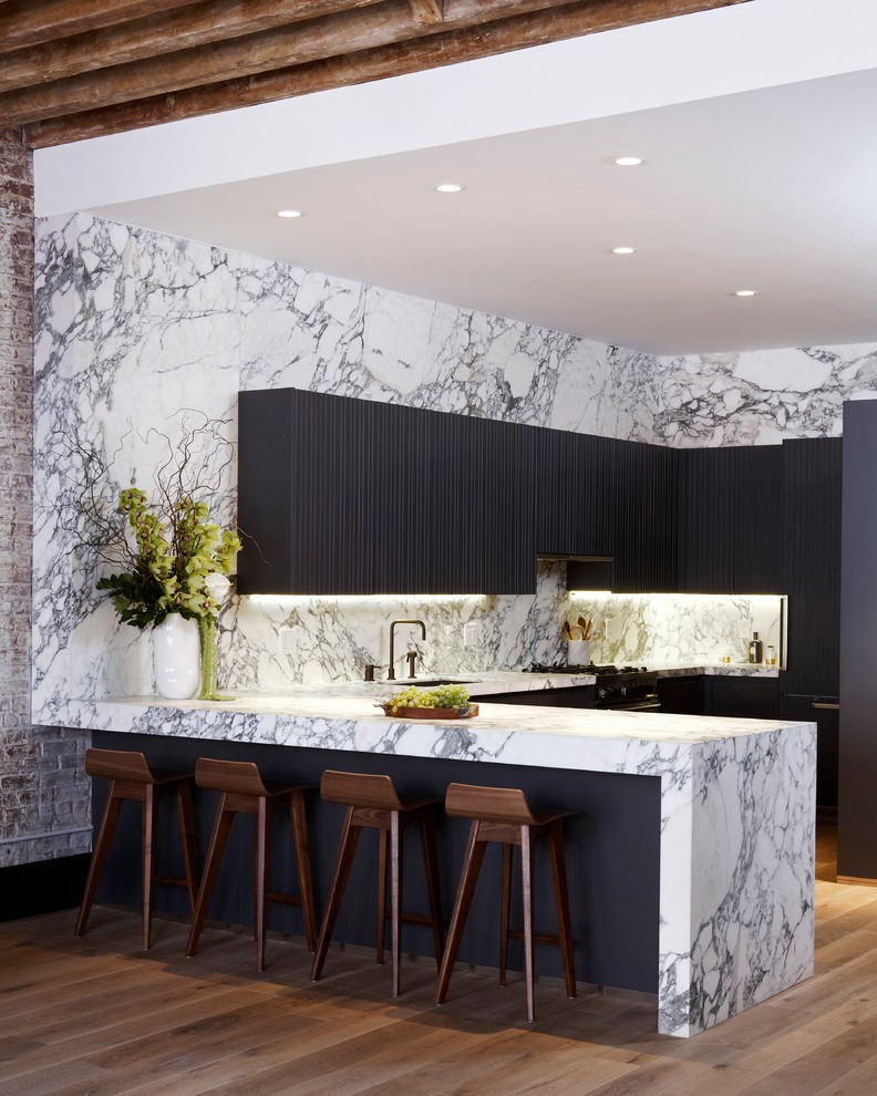 Inspiration for a mid-sized contemporary l-shaped open plan kitchen in New York with an undermount sink, flat-panel cabinets, black cabinets, multi-coloured splashback, medium hardwood floors, a peninsula, marble benchtops, marble splashback, panelled appliances and brown floor.