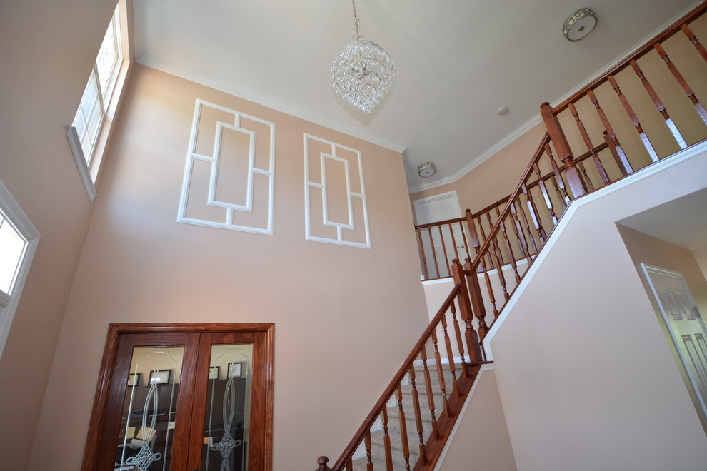 Example of a large transitional dark wood floor foyer design in Baltimore with orange walls and a white front door