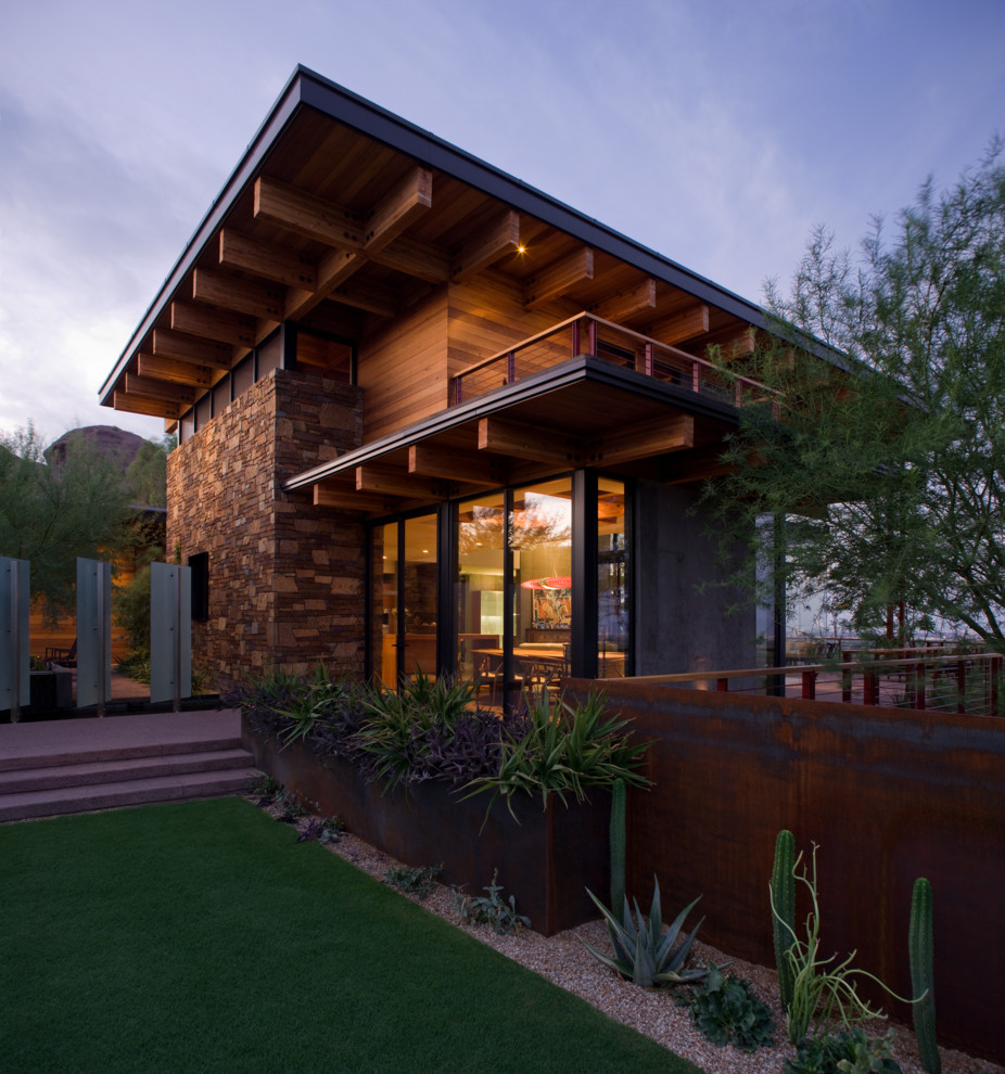 This is an example of a large contemporary two-storey brown house exterior in Phoenix with mixed siding and a shed roof.
