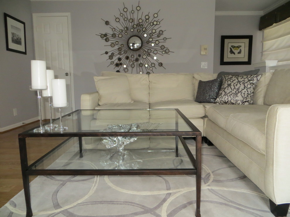 Small contemporary open concept living room in DC Metro with grey walls, a wall-mounted tv and laminate floors.