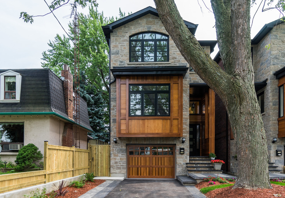 Traditional three-storey brown exterior in Toronto with stone veneer and a gable roof.