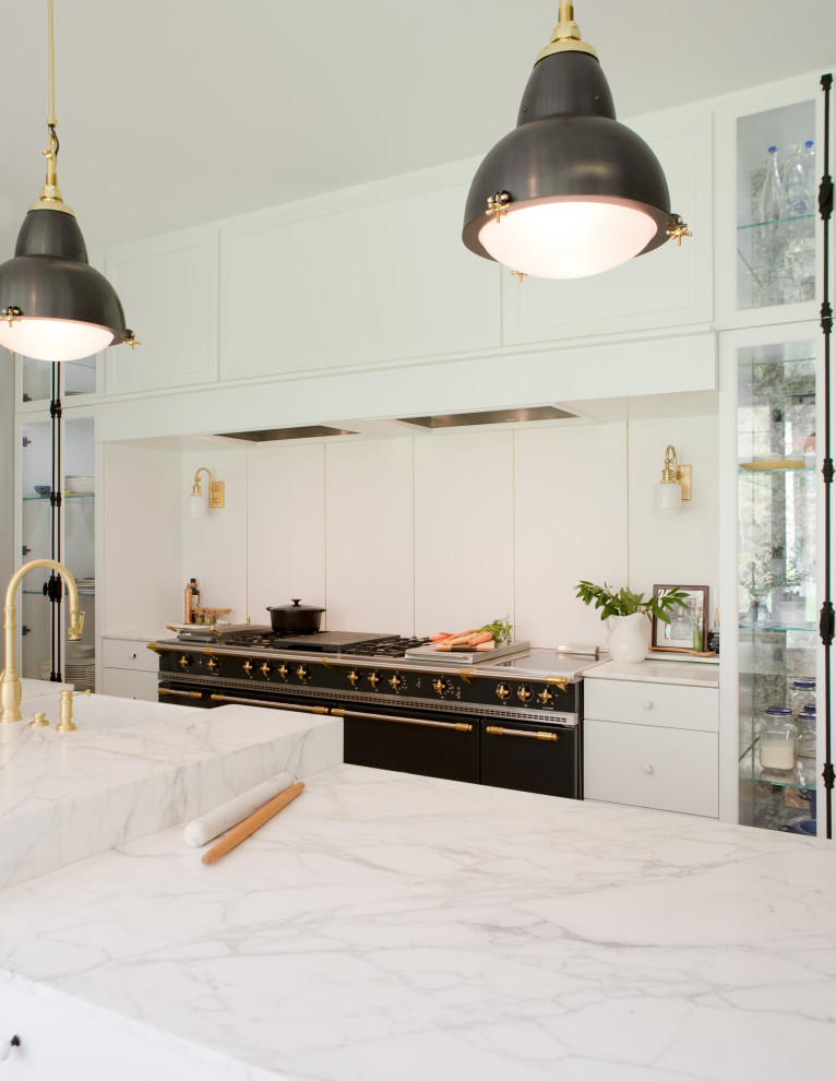 Bild på ett mellanstort vit vitt kök, med en rustik diskho, luckor med glaspanel, gula skåp, marmorbänkskiva, vitt stänkskydd, stänkskydd i porslinskakel, vita vitvaror, mellanmörkt trägolv, en köksö och brunt golv