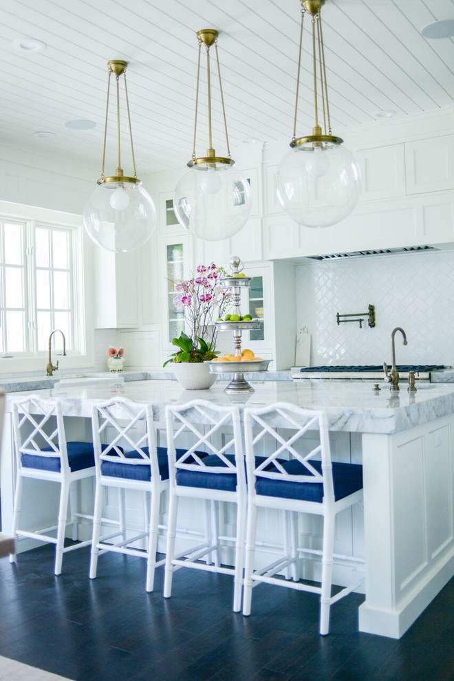 Open concept kitchen - large transitional l-shaped light wood floor open concept kitchen idea in San Diego with a farmhouse sink, shaker cabinets, wood countertops, white backsplash, mosaic tile backsplash, stainless steel appliances, an island and white cabinets