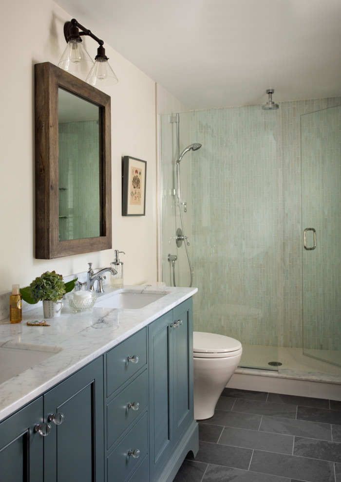 Design ideas for a mid-sized transitional master bathroom in Boston with shaker cabinets, blue cabinets, a two-piece toilet, green tile, glass tile, white walls, slate floors, an undermount sink, marble benchtops, grey floor and a hinged shower door.