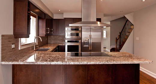 Enclosed kitchen - mid-sized transitional u-shaped enclosed kitchen idea in Austin with shaker cabinets, dark wood cabinets, granite countertops, beige backsplash, stone tile backsplash, stainless steel appliances and a peninsula