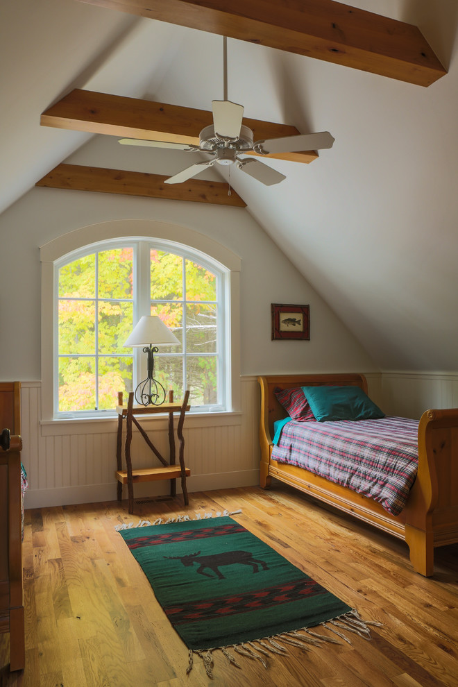 Photo of a mid-sized arts and crafts guest bedroom in Other with white walls, medium hardwood floors, no fireplace and brown floor.