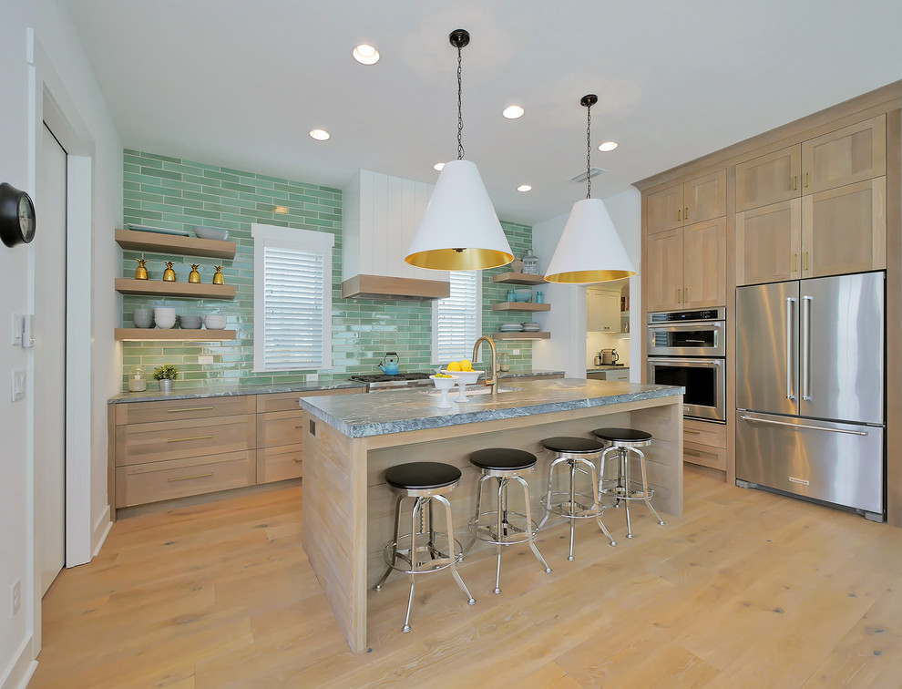 Beach style kitchen in Jacksonville with an undermount sink, shaker cabinets, light wood cabinets, green splashback, stainless steel appliances, light hardwood floors, with island and beige floor.