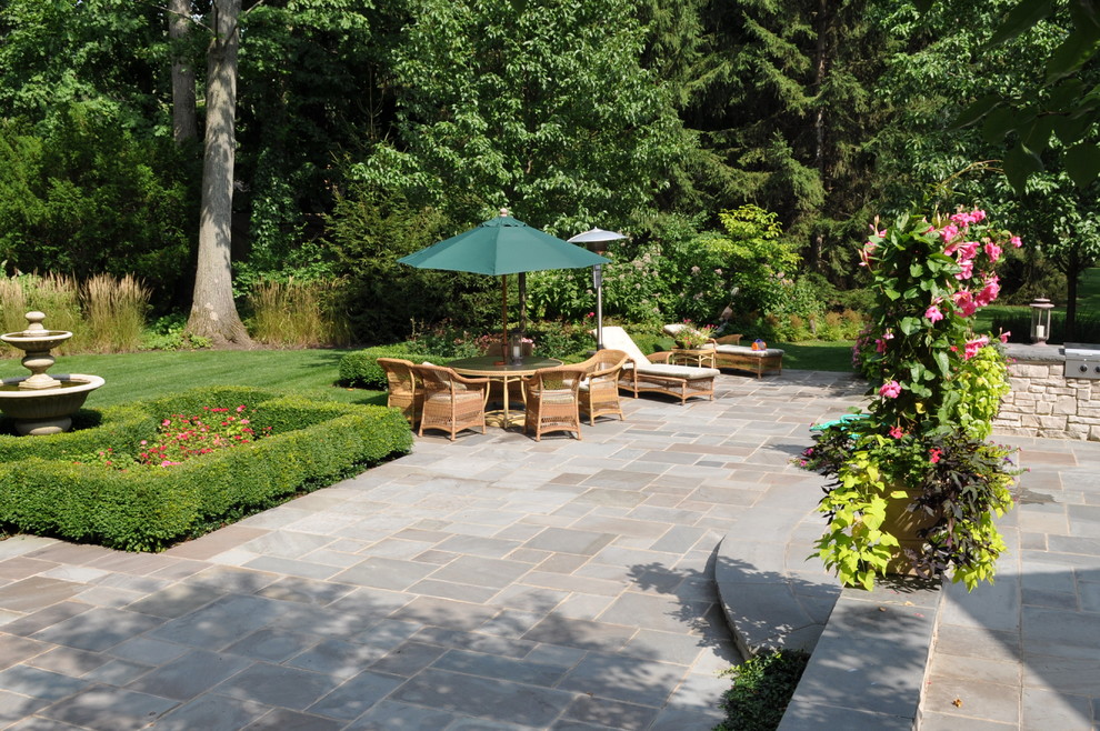 Photo of a traditional backyard garden in Chicago with natural stone pavers.