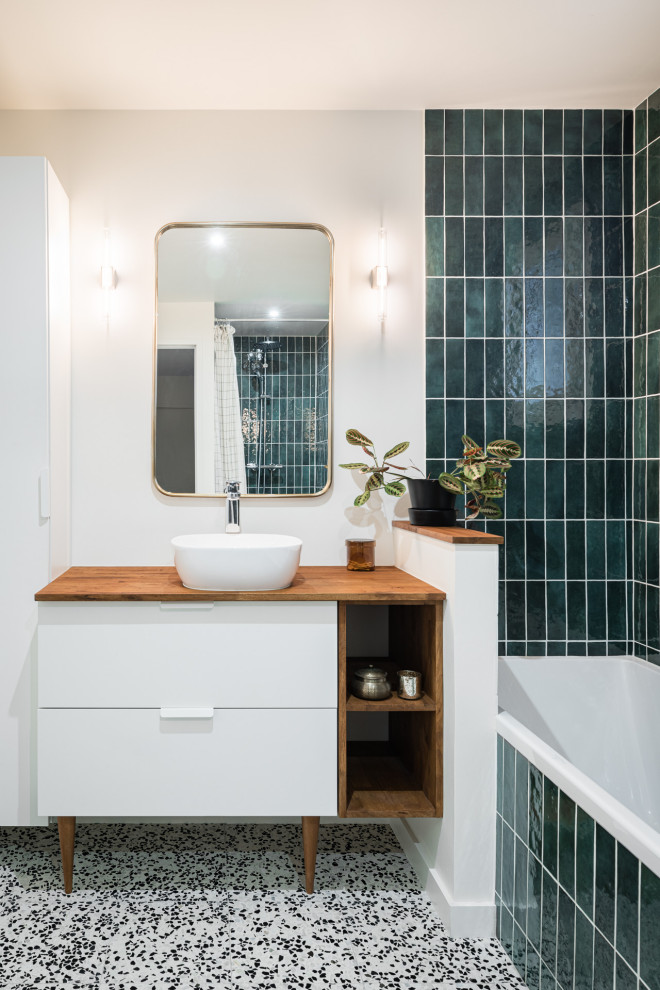 Mid-sized master bathroom in Bordeaux with white cabinets, green tile, ceramic tile, white walls, terrazzo floors, a drop-in sink, wood benchtops, a shower curtain, a single vanity and a freestanding vanity.