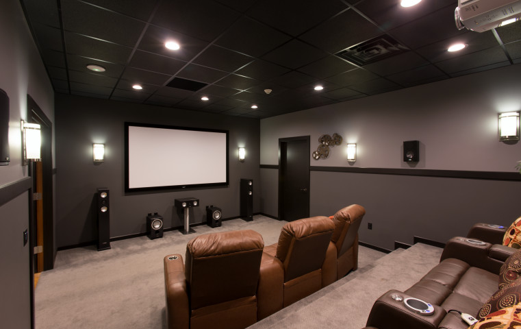 Ejemplo de cine en casa cerrado actual de tamaño medio con paredes grises, moqueta y pantalla de proyección