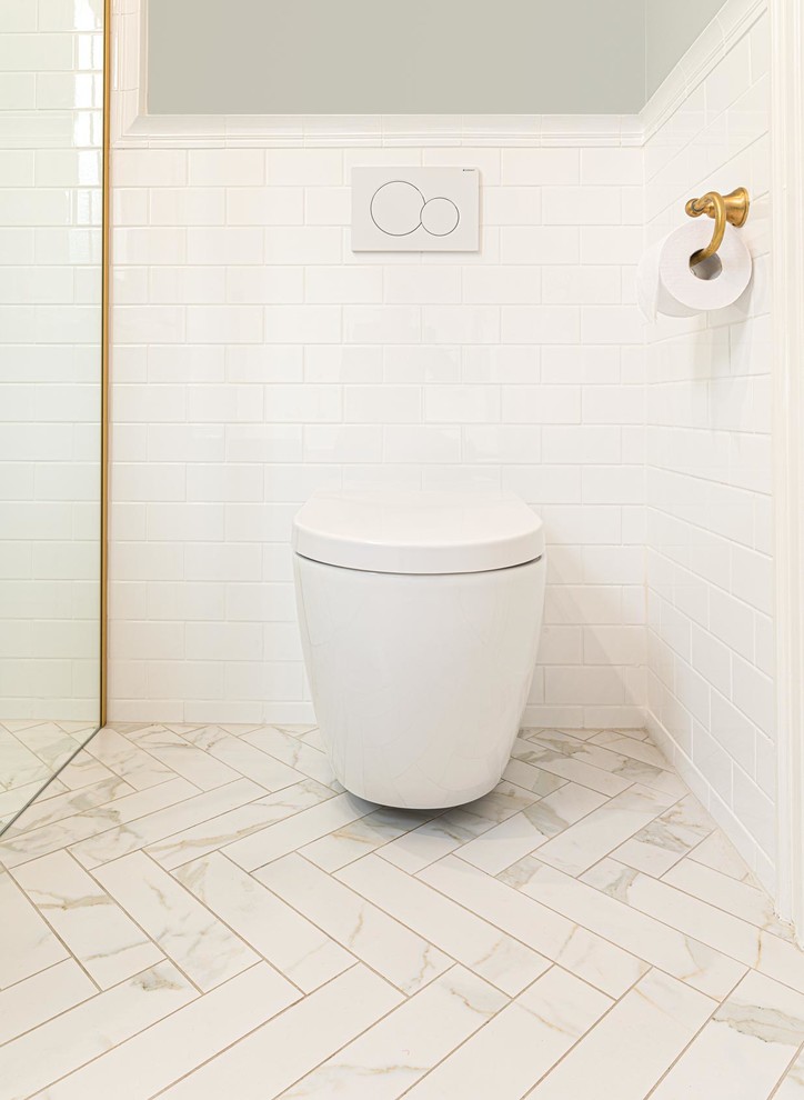 Inspiration for a mid-sized traditional 3/4 bathroom in Melbourne with shaker cabinets, blue cabinets, a drop-in tub, a curbless shower, a wall-mount toilet, white tile, ceramic tile, grey walls, porcelain floors, an undermount sink, engineered quartz benchtops, white floor, a hinged shower door and grey benchtops.