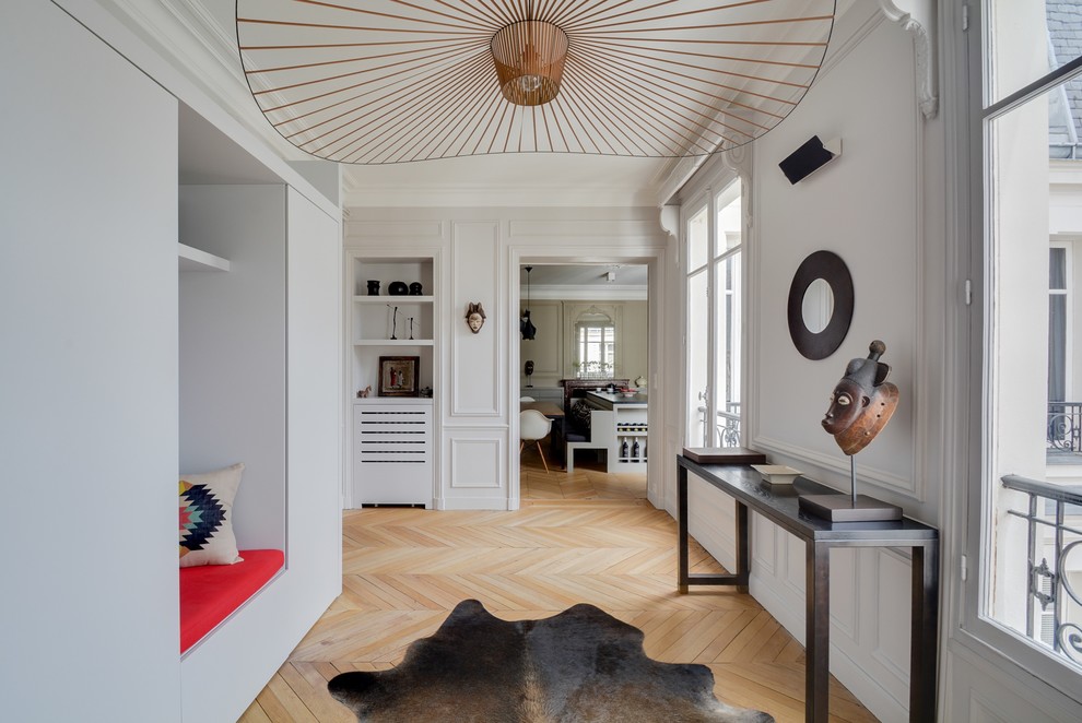 Design ideas for an expansive transitional hallway in Paris with white walls and light hardwood floors.