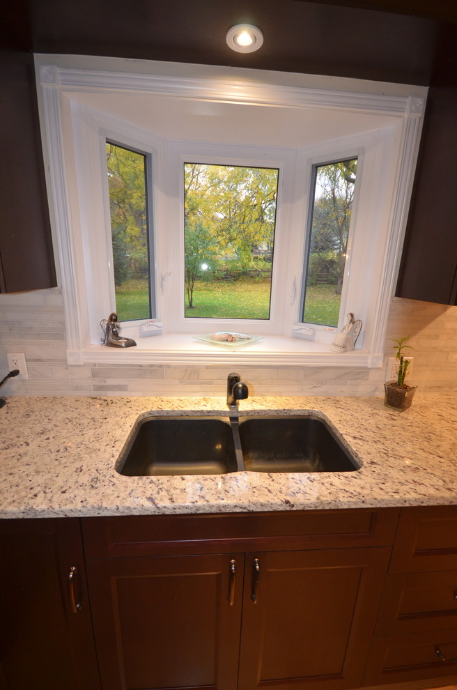 Mid-sized transitional galley medium tone wood floor and brown floor eat-in kitchen photo in Ottawa with recessed-panel cabinets, dark wood cabinets, granite countertops, gray backsplash, stainless steel appliances, a double-bowl sink, porcelain backsplash, a peninsula and beige countertops