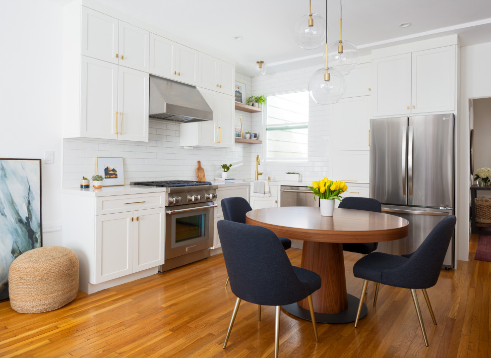 Medium sized traditional l-shaped kitchen/diner in San Francisco with a submerged sink, shaker cabinets, white cabinets, engineered stone countertops, white splashback, ceramic splashback, stainless steel appliances, light hardwood flooring, multi-coloured floors, white worktops and exposed beams.