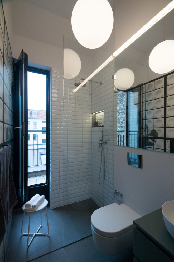 Design ideas for a small contemporary 3/4 bathroom in Berlin with flat-panel cabinets, grey cabinets, an open shower, a wall-mount toilet, white tile, ceramic tile, white walls, a vessel sink, grey floor, a single vanity, a floating vanity and wallpaper.