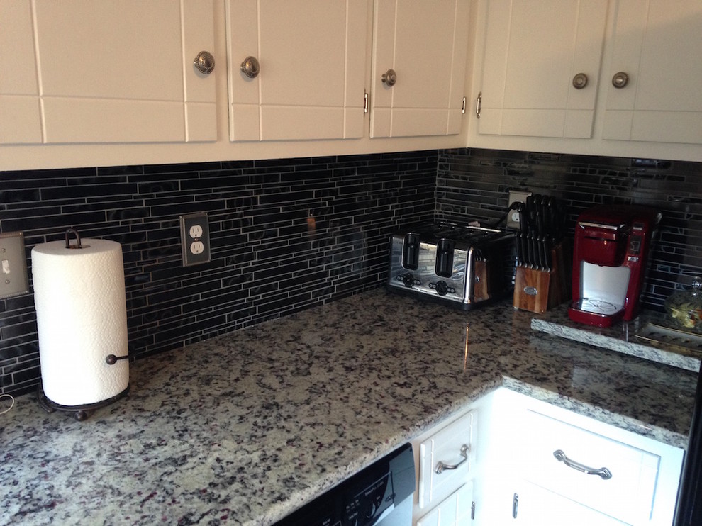 Inspiration for a mid-sized timeless l-shaped enclosed kitchen remodel in Richmond with a double-bowl sink, white cabinets, granite countertops, white backsplash, stone slab backsplash, stainless steel appliances and white countertops