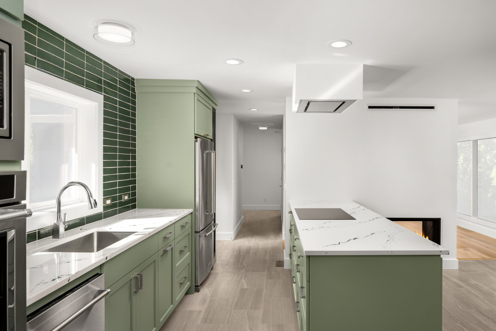 Photo of a mid-sized midcentury galley eat-in kitchen in Portland with an undermount sink, shaker cabinets, green cabinets, quartz benchtops, green splashback, cement tile splashback, stainless steel appliances, porcelain floors, a peninsula, grey floor and multi-coloured benchtop.
