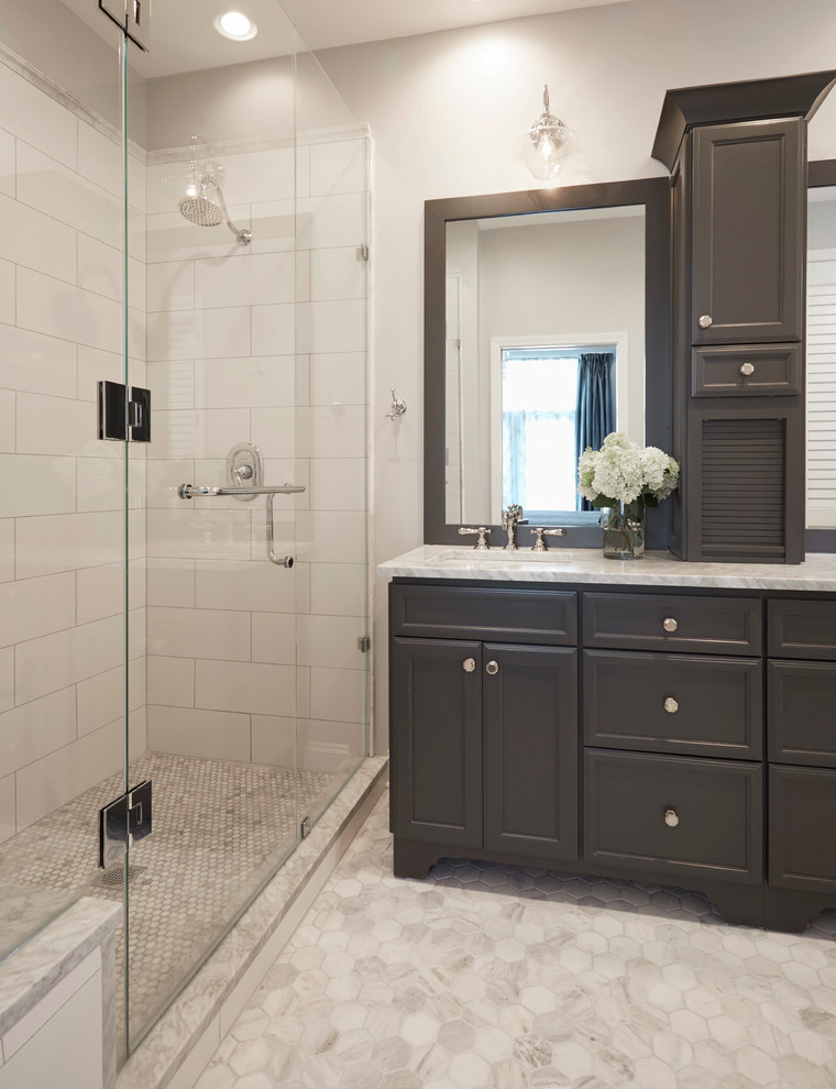 This is an example of a mid-sized transitional master bathroom in Chicago with shaker cabinets, grey cabinets, an alcove shower, a one-piece toilet, white tile, mosaic tile, grey walls, marble floors, an undermount sink and marble benchtops.