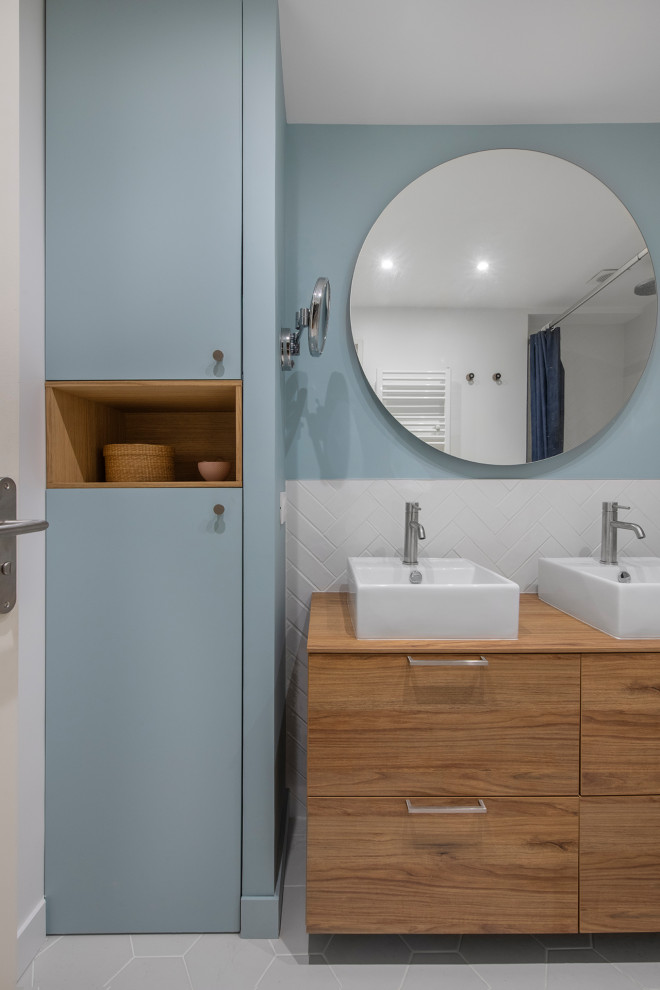 Idéer för att renovera ett mellanstort funkis beige beige en-suite badrum, med luckor med profilerade fronter, skåp i mellenmörkt trä, ett platsbyggt badkar, en dusch/badkar-kombination, vit kakel, perrakottakakel, blå väggar, klinkergolv i keramik, ett fristående handfat, träbänkskiva, grått golv och med dusch som är öppen