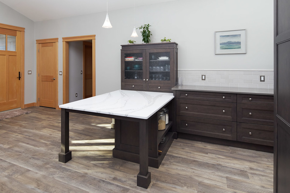 Small transitional u-shaped medium tone wood floor and gray floor open concept kitchen photo in Calgary with an undermount sink, recessed-panel cabinets, dark wood cabinets, quartz countertops, gray backsplash, subway tile backsplash, stainless steel appliances and a peninsula