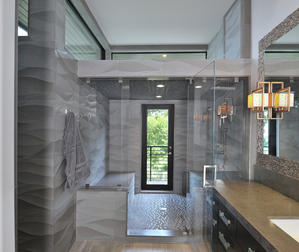 Photo of a contemporary bathroom in Houston with an undermount sink, flat-panel cabinets, an alcove shower and gray tile.