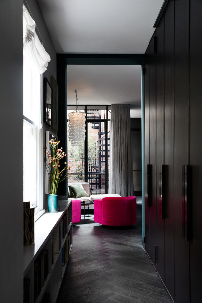 This is an example of an eclectic hallway in Melbourne with dark hardwood floors and black floor.