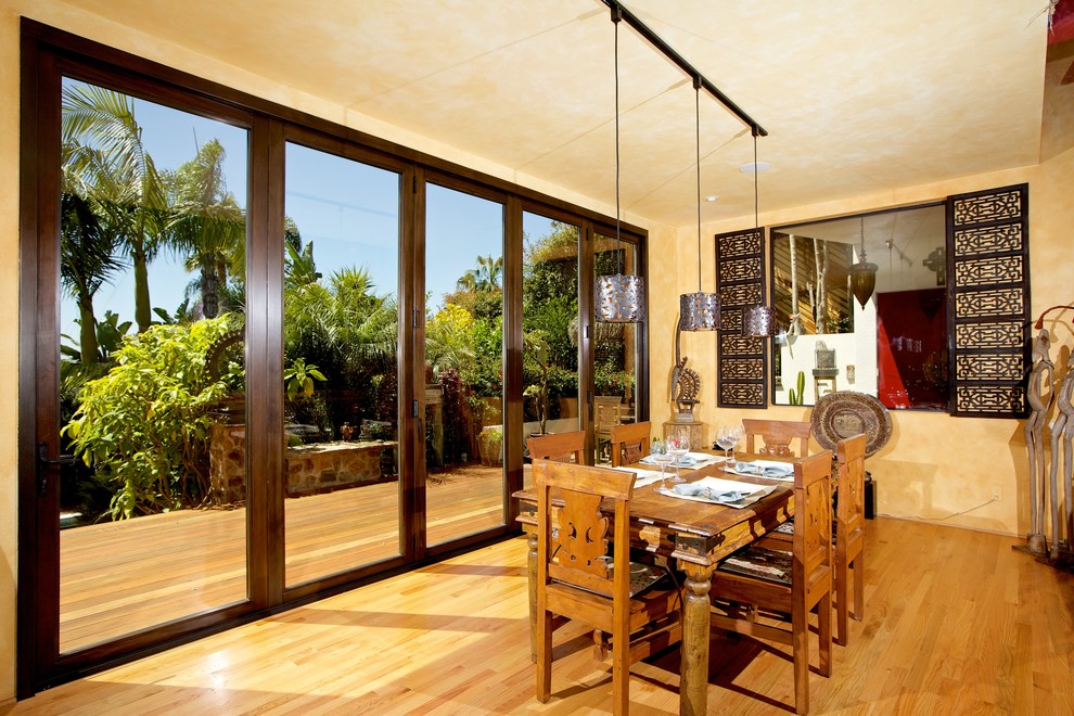 This is an example of a tropical separate dining room in San Diego with medium hardwood floors and no fireplace.