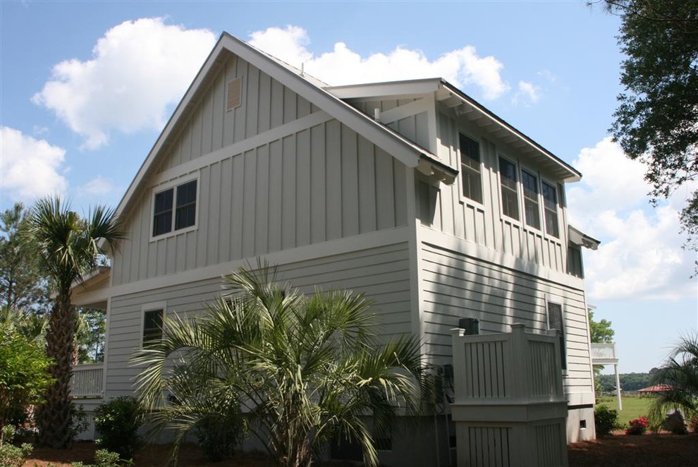 This is an example of a small country two-storey grey house exterior in Charleston with concrete fiberboard siding, a gable roof and a metal roof.