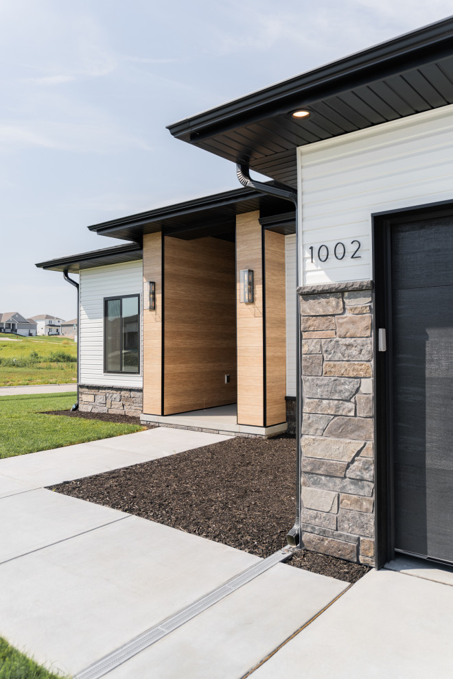 Inspiration for a transitional concrete floor and wood wall front door remodel with brown walls and a black front door