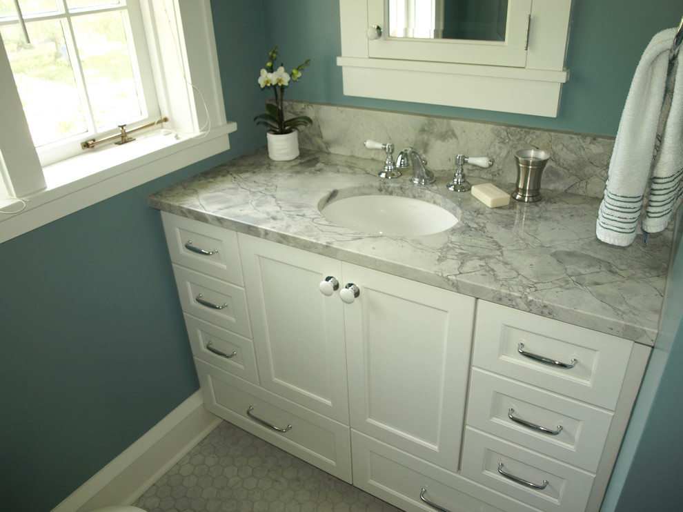 Photo of a mid-sized traditional kids bathroom in Cleveland with shaker cabinets, white cabinets, an alcove tub, a shower/bathtub combo, a one-piece toilet, white tile, ceramic tile, blue walls, marble floors, an undermount sink and quartzite benchtops.