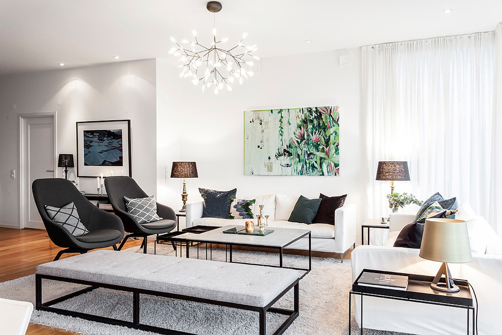 This is an example of a large contemporary formal open concept living room in Gothenburg with white walls, medium hardwood floors, no fireplace, no tv and brown floor.