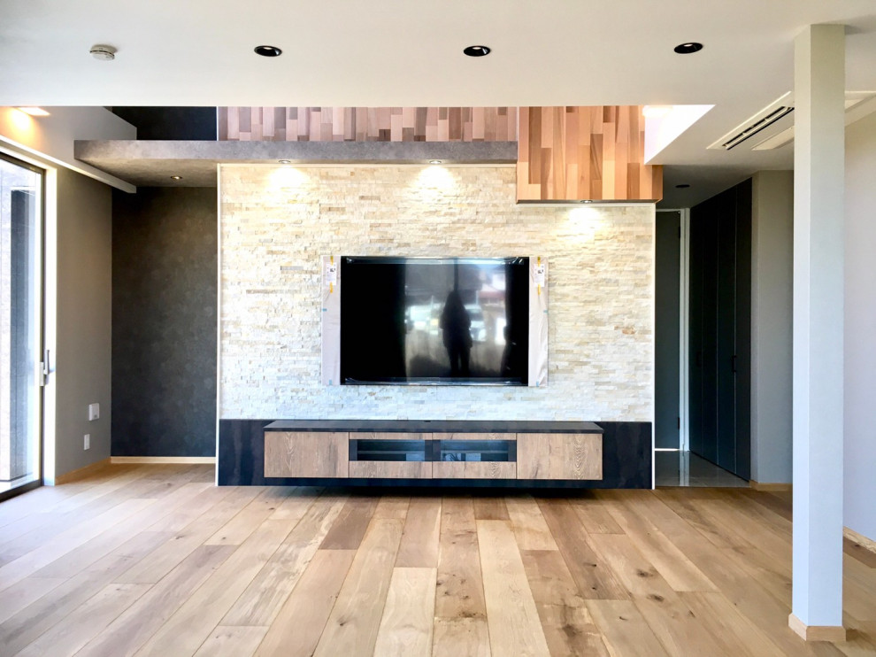Cette image montre un salon minimaliste ouvert avec un mur gris, parquet clair, un téléviseur fixé au mur, un sol marron, un plafond en papier peint et du papier peint.