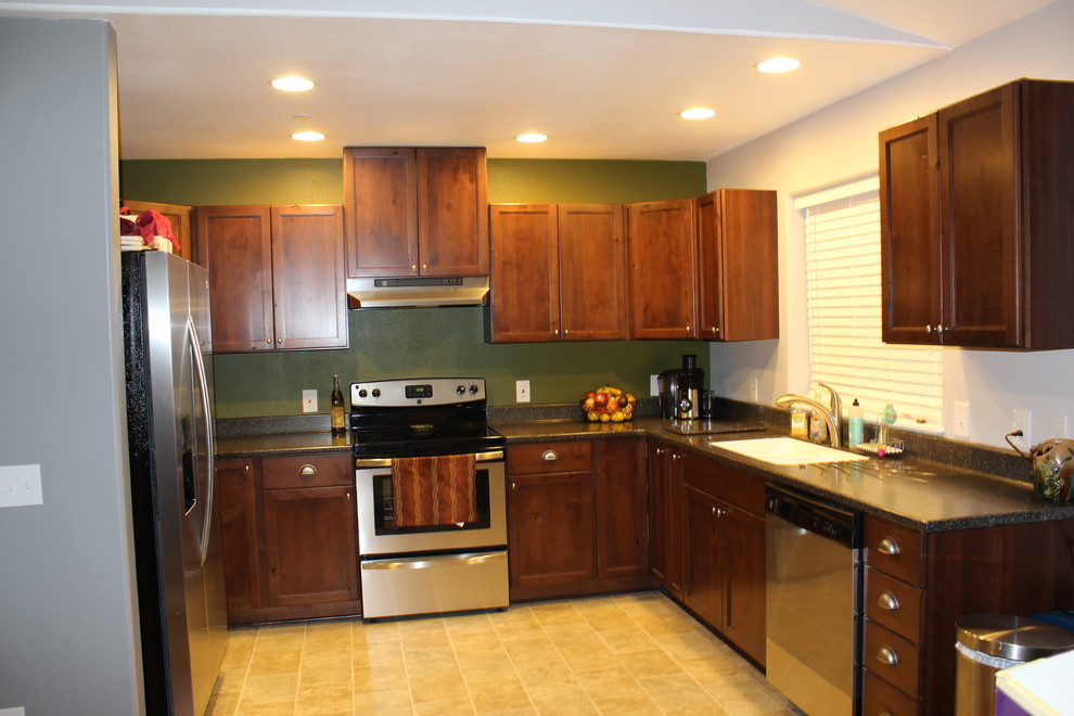 Kitchen - traditional kitchen idea with an integrated sink, flat-panel cabinets, solid surface countertops and stainless steel appliances