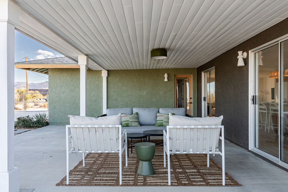 Foto di un patio o portico design dietro casa con lastre di cemento