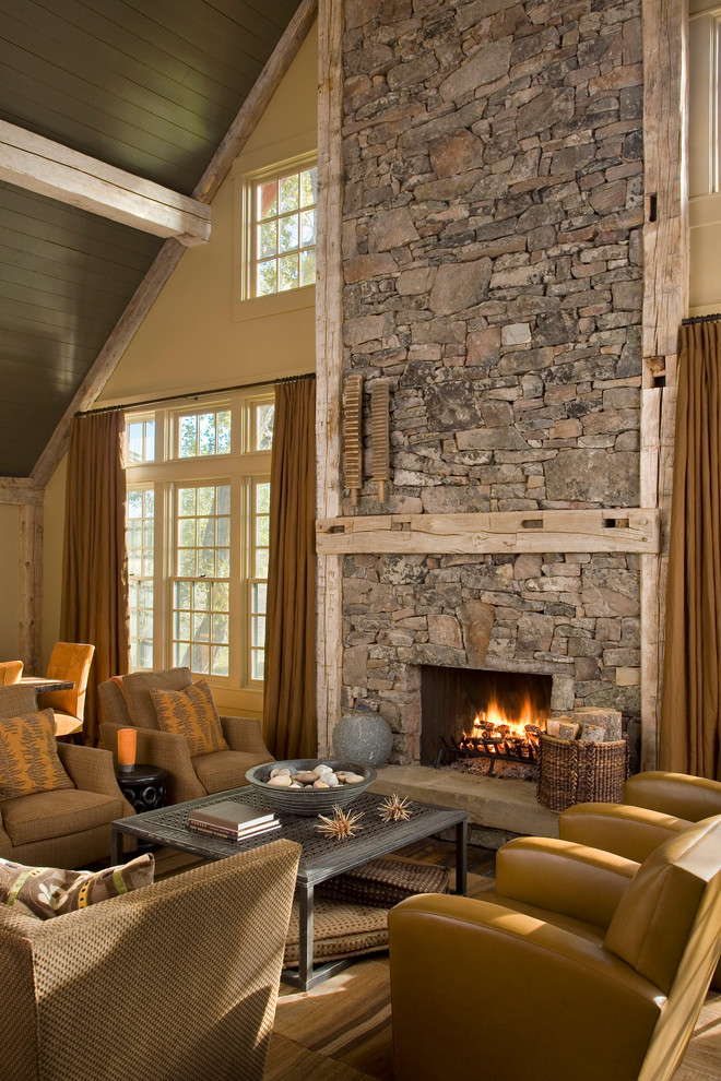 Small country loft-style living room in Other with beige walls, medium hardwood floors, a standard fireplace and a stone fireplace surround.