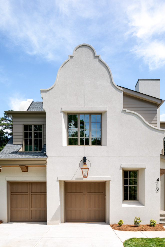 Стильный дизайн: двухэтажный, белый частный загородный дом в классическом стиле с облицовкой из цементной штукатурки, крышей из гибкой черепицы и отделкой доской с нащельником - последний тренд