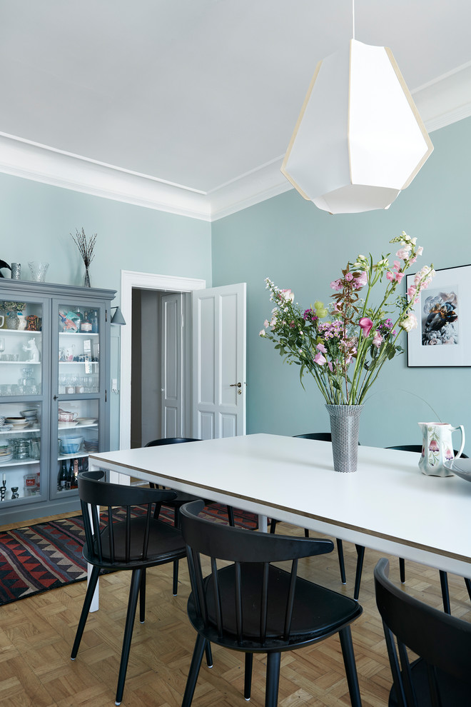 Design ideas for a scandinavian separate dining room in Copenhagen with blue walls, light hardwood floors and beige floor.