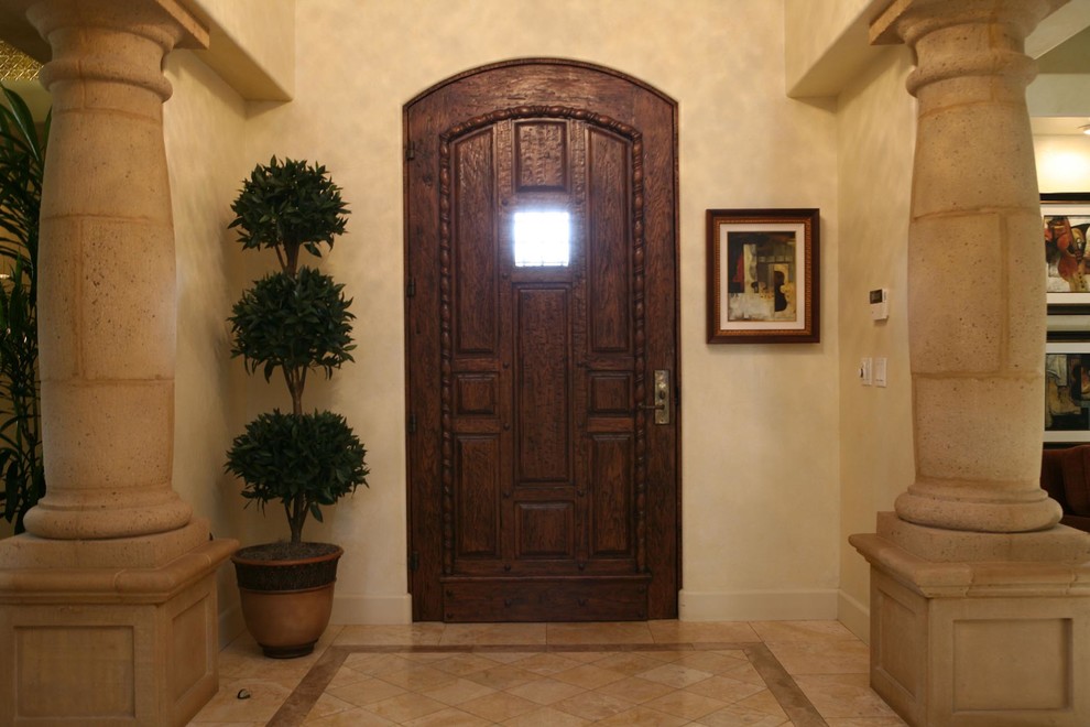 Large mediterranean entry hall in Orange County with beige walls, a single front door and a dark wood front door.