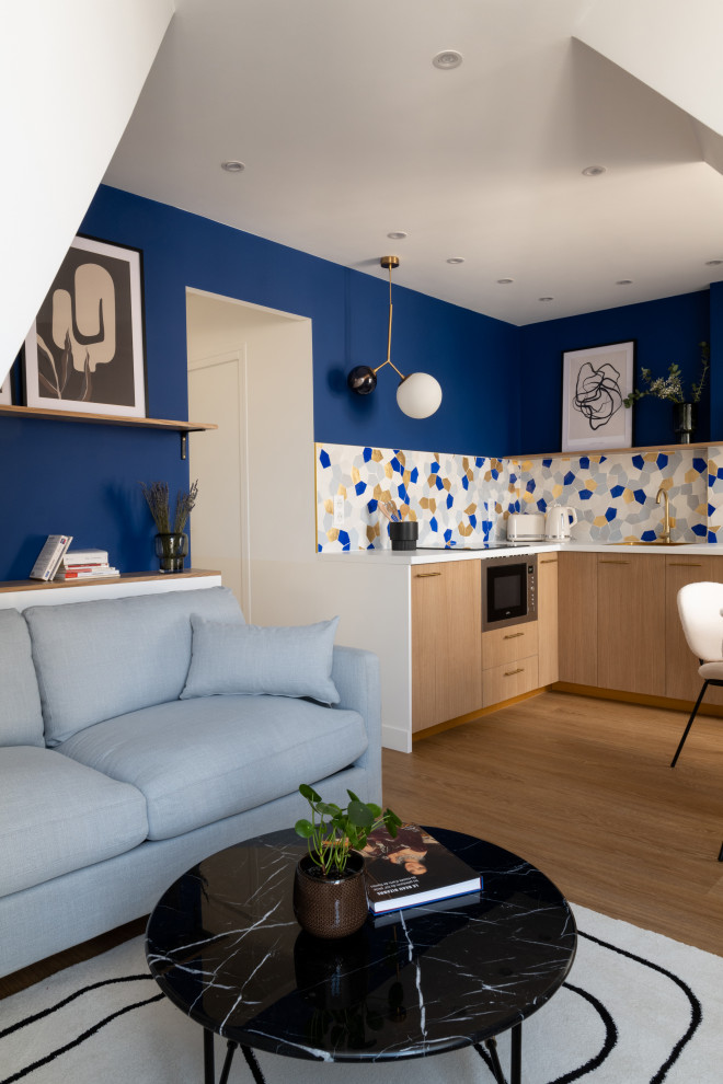 Aménagement d'une salle de séjour mansardée ou avec mezzanine contemporaine de taille moyenne avec un mur bleu, un sol en bois brun, un téléviseur indépendant, un sol marron et éclairage.