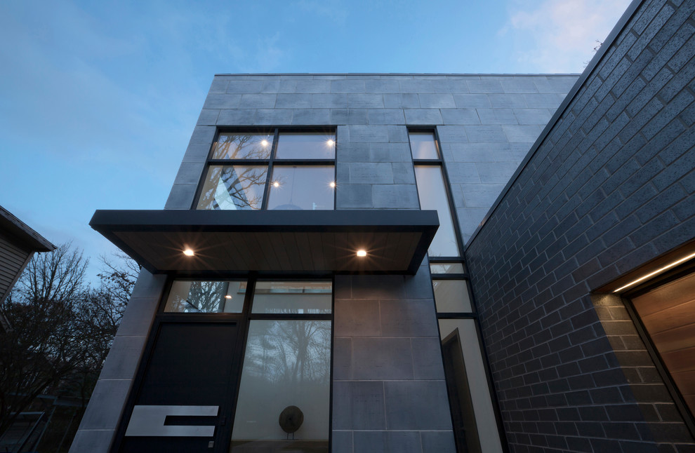Photo of a mid-sized modern two-storey concrete grey house exterior in Chicago with a flat roof.