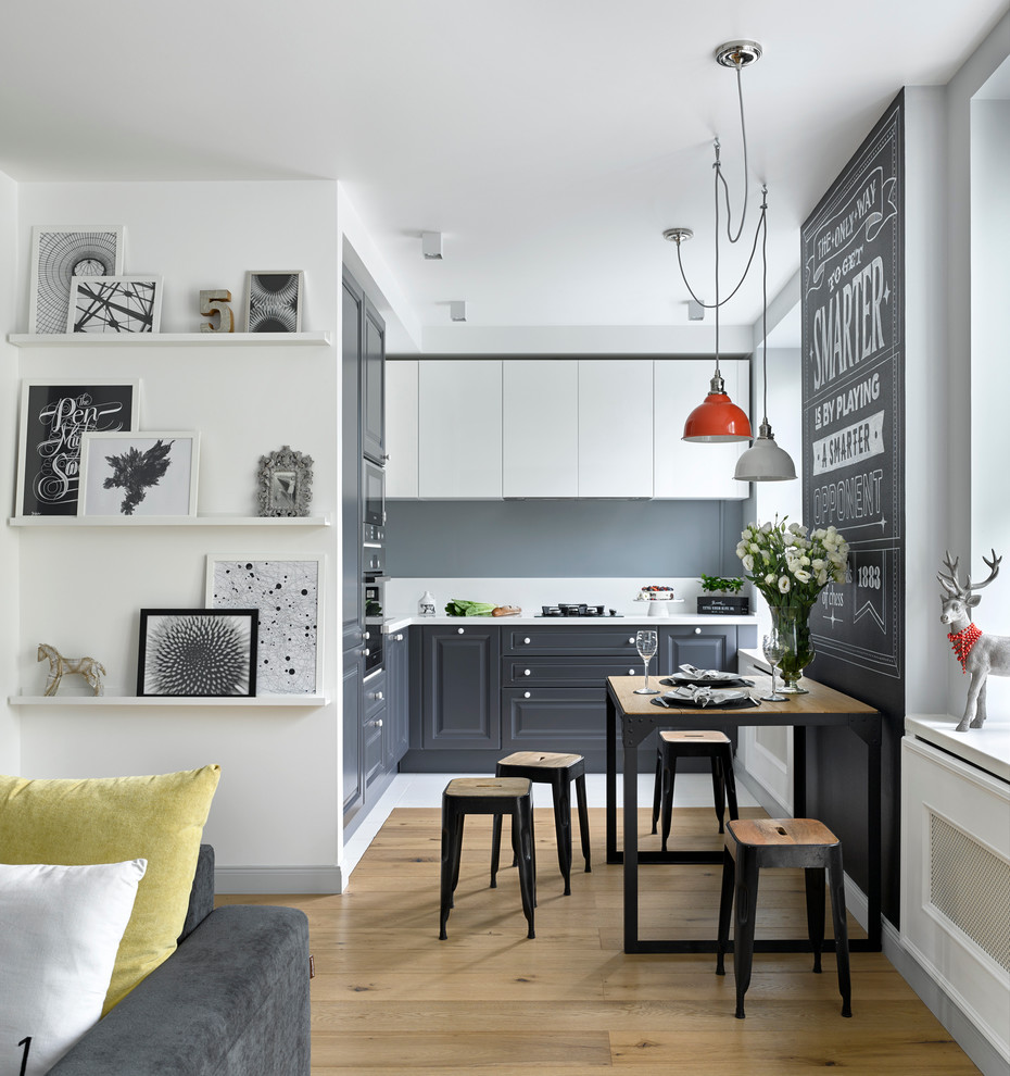 Small scandinavian kitchen in Moscow with raised-panel cabinets, grey cabinets, light hardwood floors and no island.