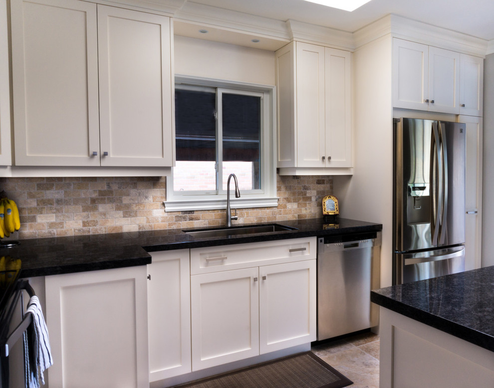 Example of a large transitional u-shaped ceramic tile enclosed kitchen design in Toronto with an undermount sink, shaker cabinets, white cabinets, granite countertops, beige backsplash, stainless steel appliances, a peninsula and brick backsplash