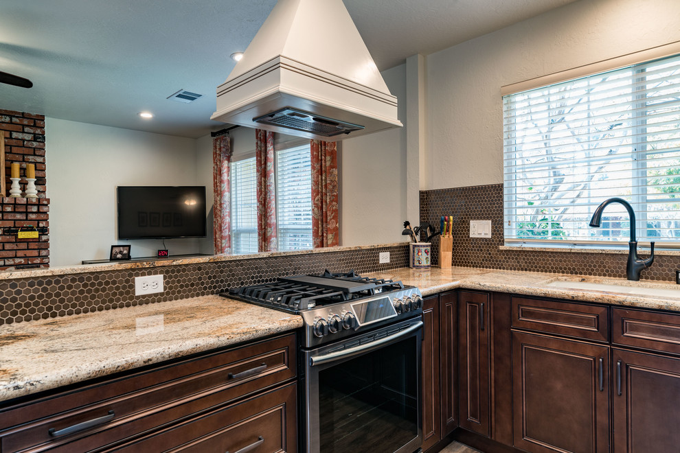 Mid-sized transitional u-shaped medium tone wood floor and brown floor eat-in kitchen photo with an undermount sink, recessed-panel cabinets, white cabinets, granite countertops, brown backsplash, mosaic tile backsplash, stainless steel appliances and no island