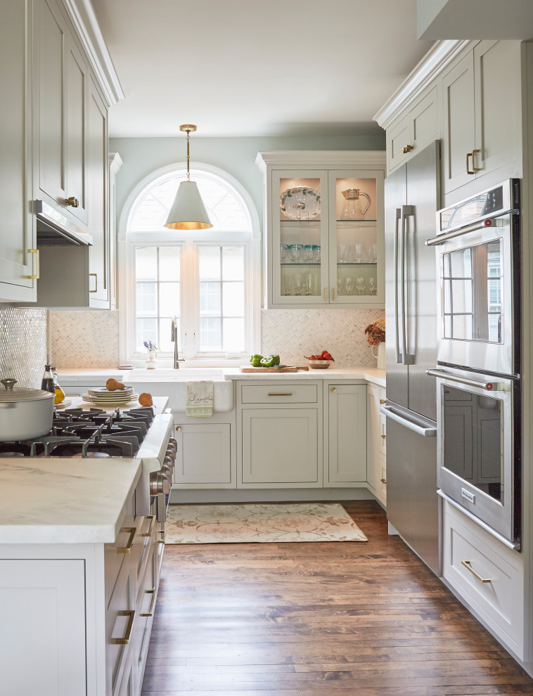 Small traditional l-shaped separate kitchen in Chicago with a farmhouse sink, beaded inset cabinets, marble benchtops, grey splashback, marble splashback, stainless steel appliances, medium hardwood floors and white benchtop.