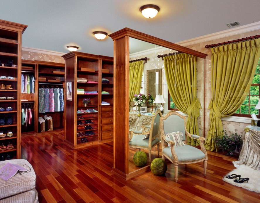 Design ideas for a large arts and crafts gender-neutral walk-in wardrobe in New York with recessed-panel cabinets, dark wood cabinets, dark hardwood floors and brown floor.