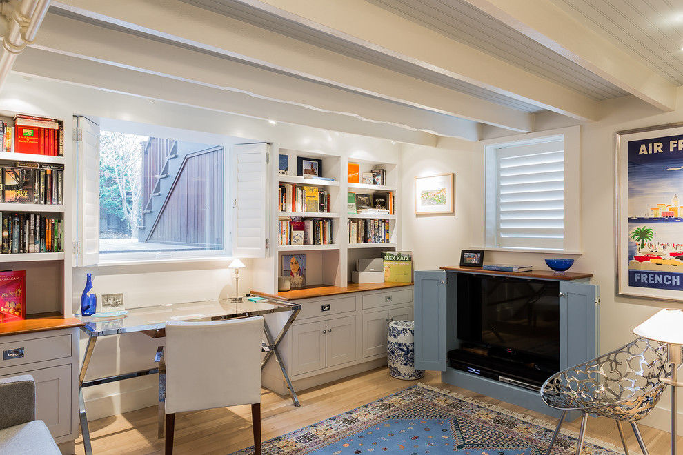 Photo of a small transitional home office in Boston with light hardwood floors, white walls and beige floor.