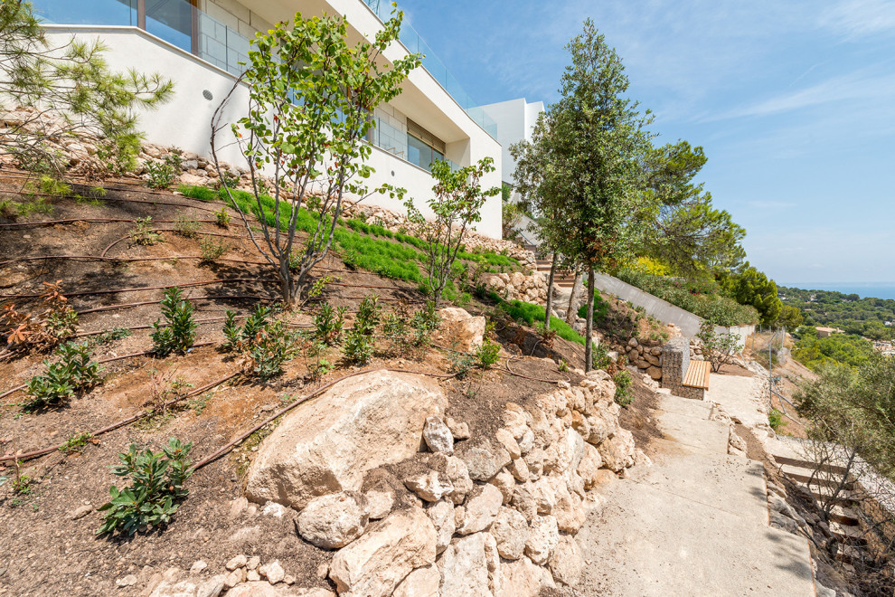 Foto de fachada de casa mediterránea con revestimiento de piedra y escaleras