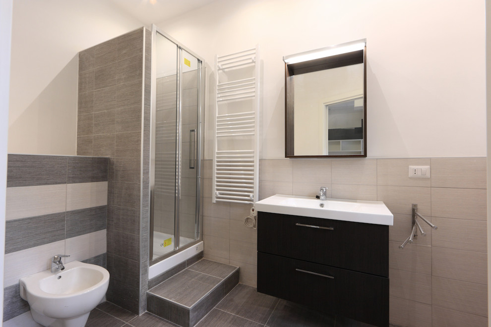This is an example of a small contemporary 3/4 bathroom in Rome with dark wood cabinets, an alcove shower, a two-piece toilet, black and white tile, porcelain tile, white walls, porcelain floors, a trough sink, black floor and a hinged shower door.