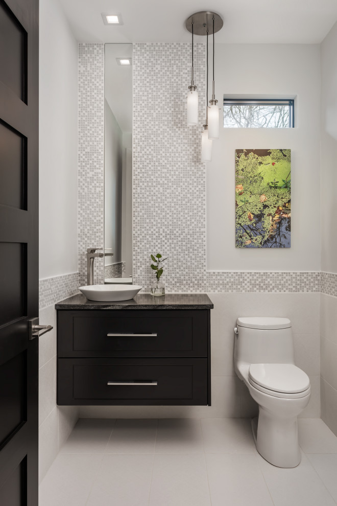 Réalisation d'un petit WC et toilettes design en bois foncé avec WC à poser, un carrelage gris, un mur blanc, une vasque, un plan de toilette en granite, un sol blanc, un plan de toilette noir et meuble-lavabo suspendu.