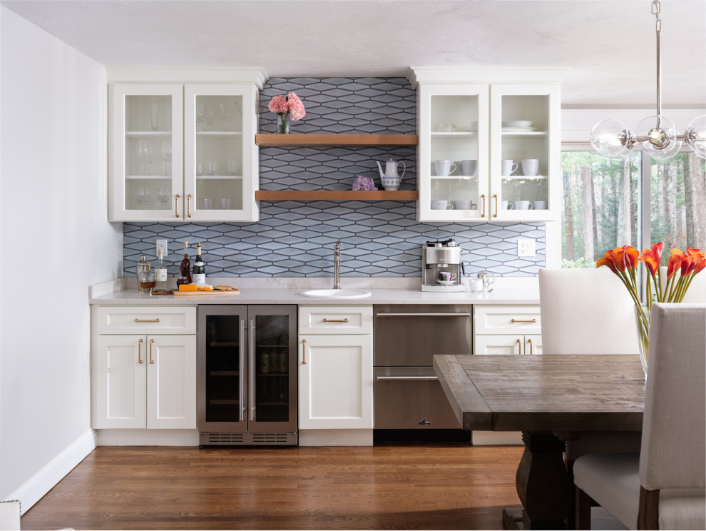 Kitchen - large transitional l-shaped medium tone wood floor and brown floor kitchen idea in Boston with white cabinets, blue backsplash, an island and white countertops